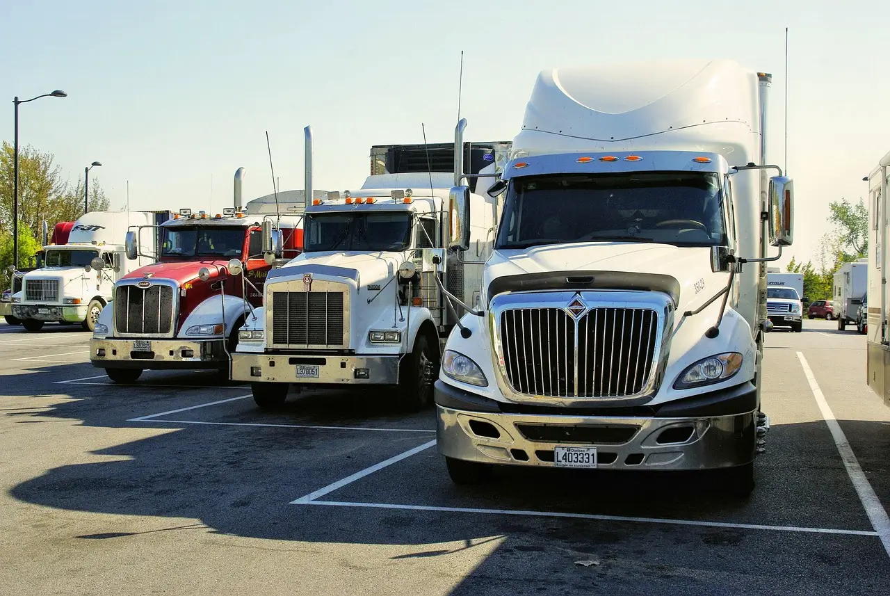 Semi trucks parked in a dealer lot during daylight